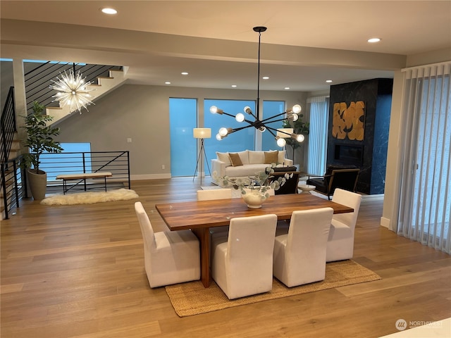 dining space featuring light hardwood / wood-style flooring and a chandelier