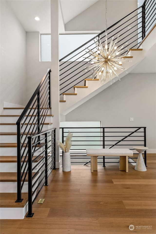 stairway featuring hardwood / wood-style floors and a notable chandelier