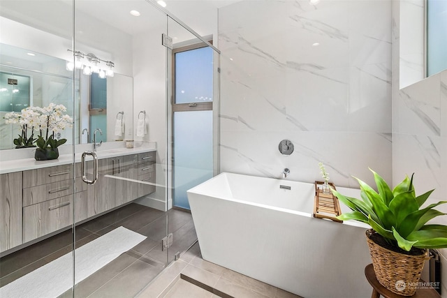 bathroom with plus walk in shower, vanity, and tile patterned floors