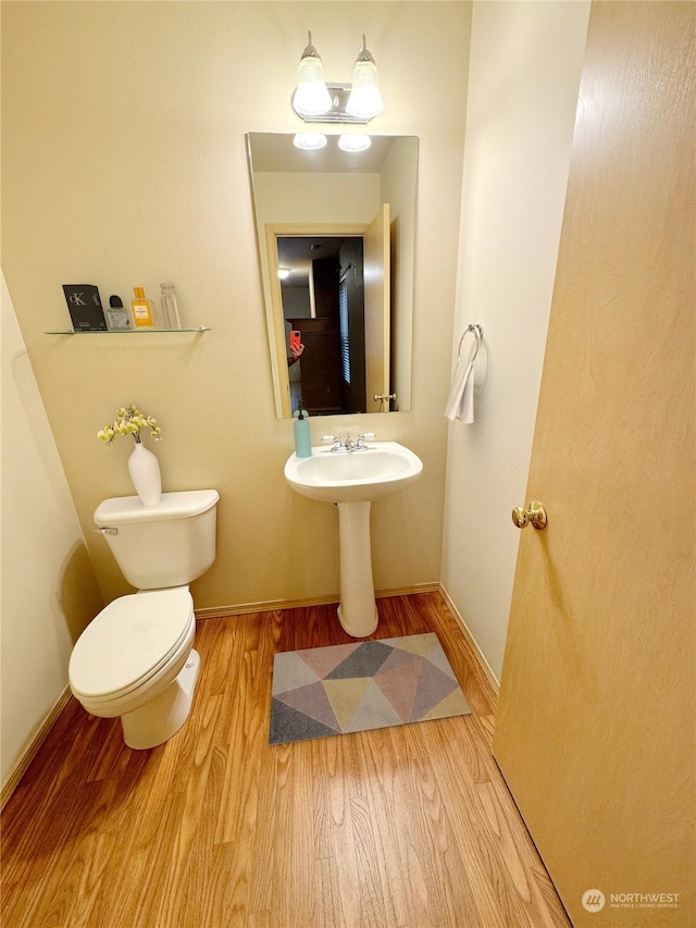 bathroom featuring hardwood / wood-style flooring and toilet