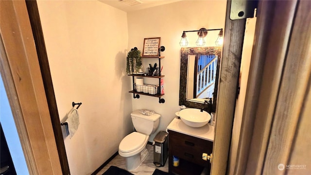 bathroom with tile patterned flooring, vanity, and toilet