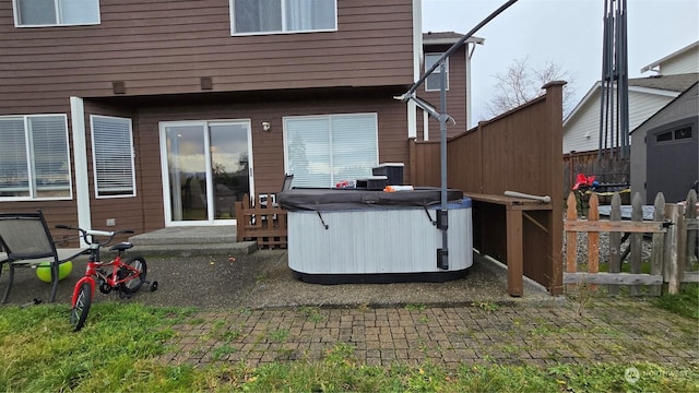 back of property featuring a patio area and a hot tub