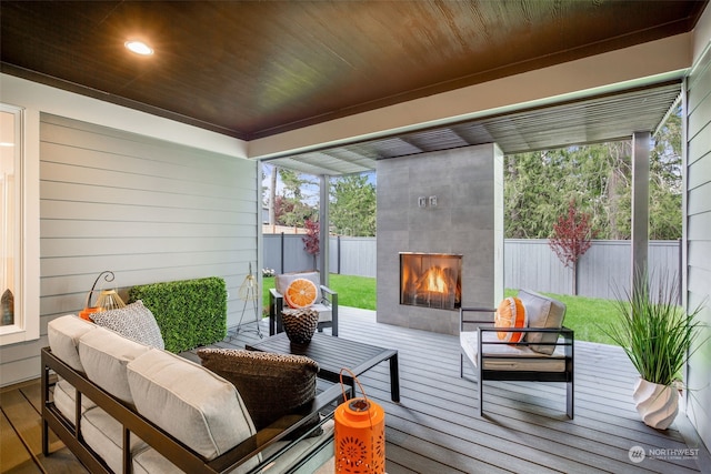 sunroom / solarium featuring plenty of natural light, wood ceiling, and exterior fireplace