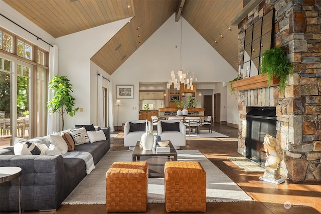 living room with wood ceiling, a fireplace, high vaulted ceiling, and a chandelier