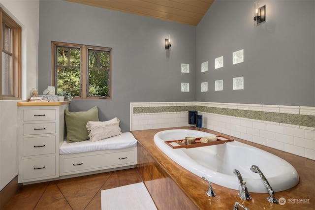 bathroom with tile patterned flooring, tiled bath, lofted ceiling, and wooden ceiling