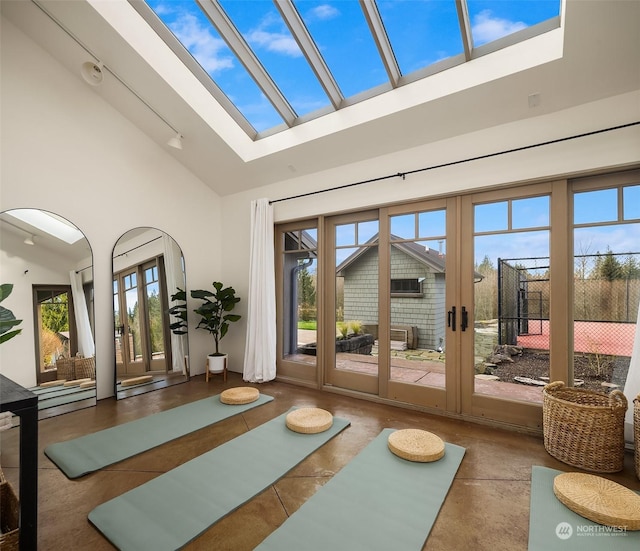 doorway featuring french doors, a skylight, high vaulted ceiling, and plenty of natural light