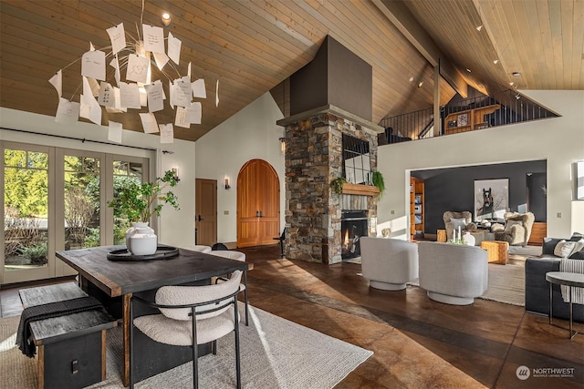 dining space with a fireplace, high vaulted ceiling, beamed ceiling, and wood ceiling