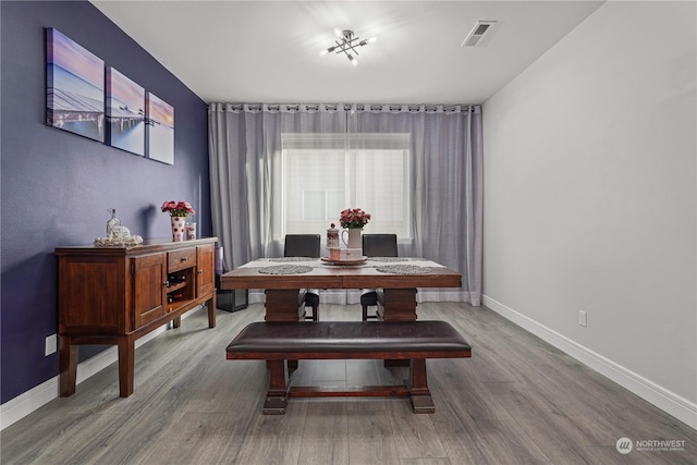 dining space with wood-type flooring