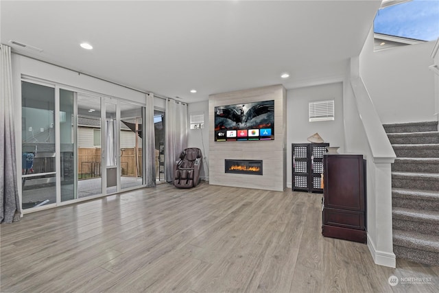 unfurnished living room with a fireplace and light hardwood / wood-style flooring