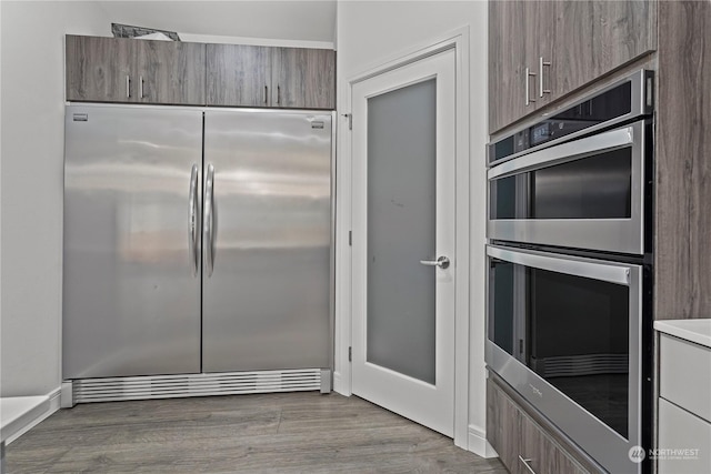 kitchen with light hardwood / wood-style flooring and appliances with stainless steel finishes