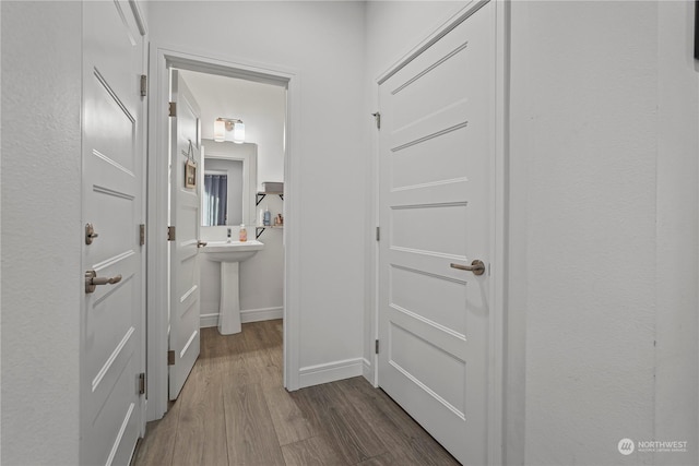 hallway with hardwood / wood-style floors and sink