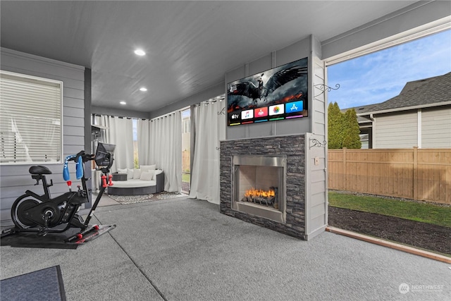 exercise area featuring a stone fireplace and carpet floors