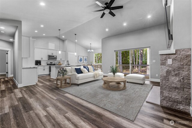 living room with dark hardwood / wood-style flooring, high vaulted ceiling, ceiling fan with notable chandelier, and sink