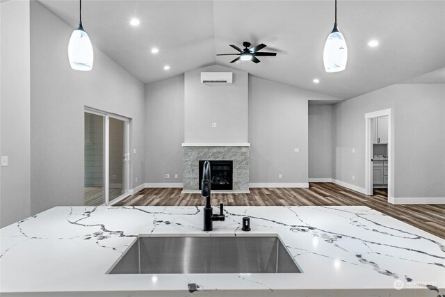 kitchen with light stone countertops, pendant lighting, and sink