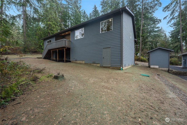 rear view of house with a deck and a storage shed