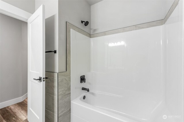 bathroom with shower / bathing tub combination and hardwood / wood-style flooring