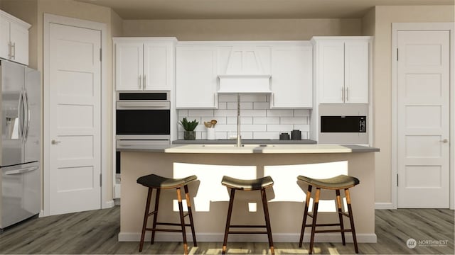 kitchen featuring dark wood-type flooring, white cabinetry, white fridge with ice dispenser, and a breakfast bar area