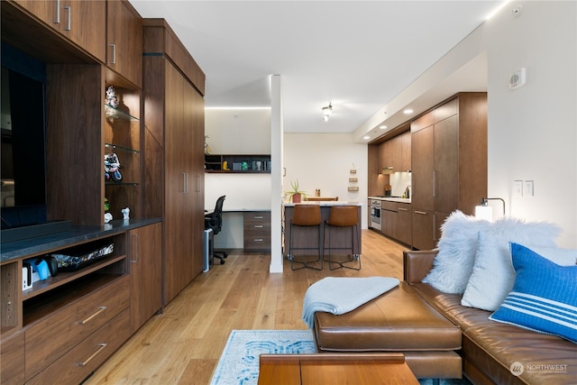 living room with built in desk and light hardwood / wood-style floors