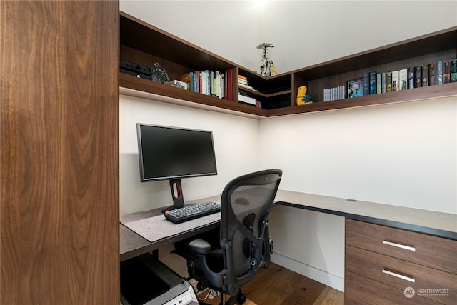 office space featuring wood-type flooring and built in desk