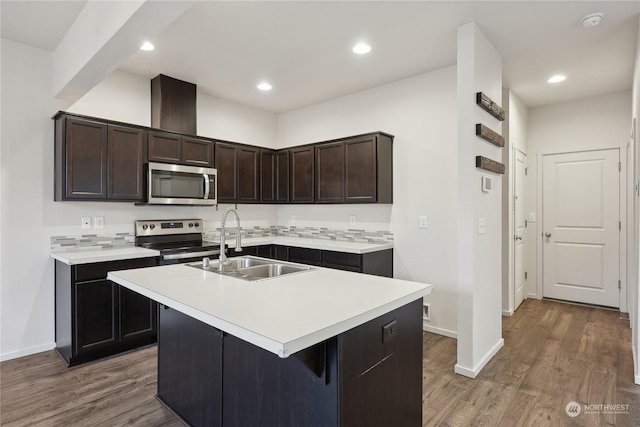 kitchen featuring a kitchen island with sink, stainless steel appliances, dark hardwood / wood-style floors, sink, and dark brown cabinets