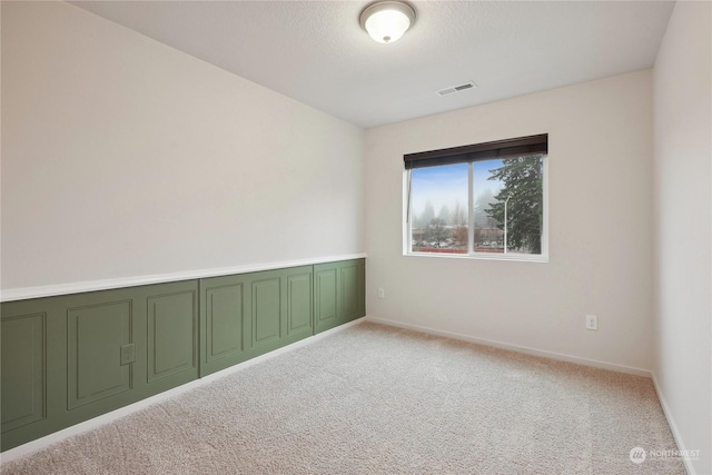 spare room featuring light colored carpet