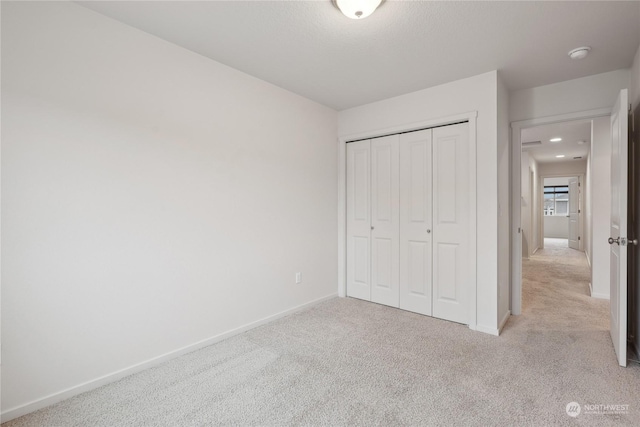 unfurnished bedroom featuring a closet and light carpet