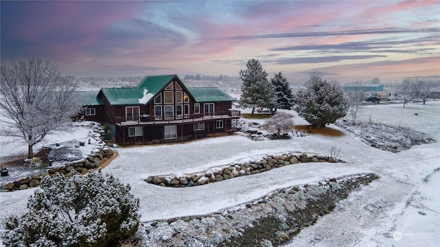 snow covered house featuring a wooden deck