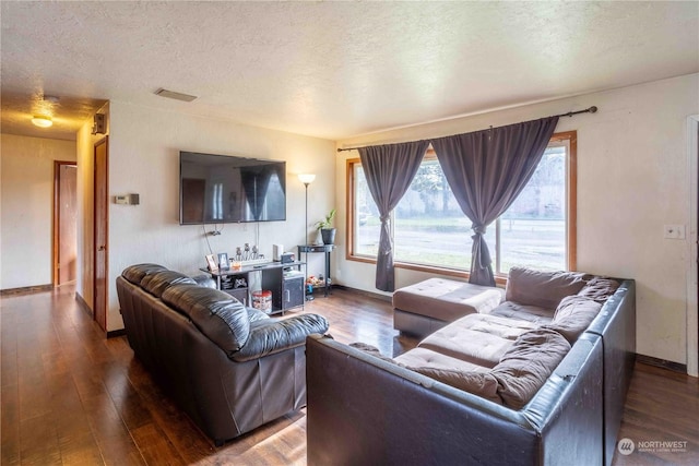 living room featuring dark hardwood / wood-style floors and a textured ceiling