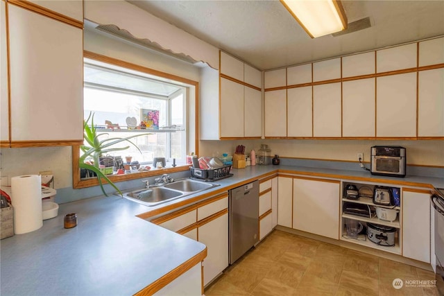 kitchen featuring stainless steel dishwasher, white cabinets, and sink