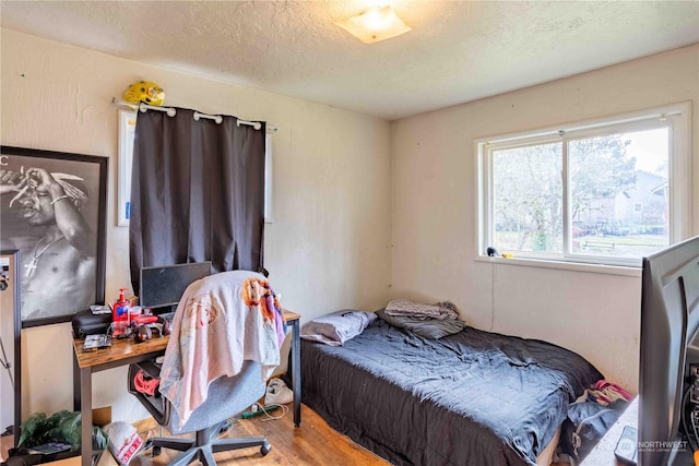 bedroom featuring wood-type flooring and a textured ceiling