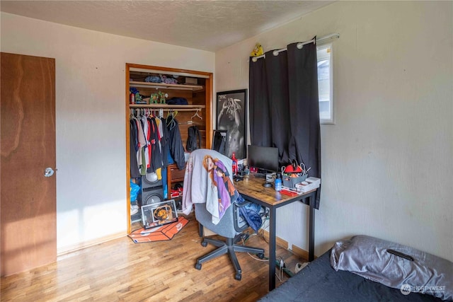 bedroom with wood-type flooring and a closet