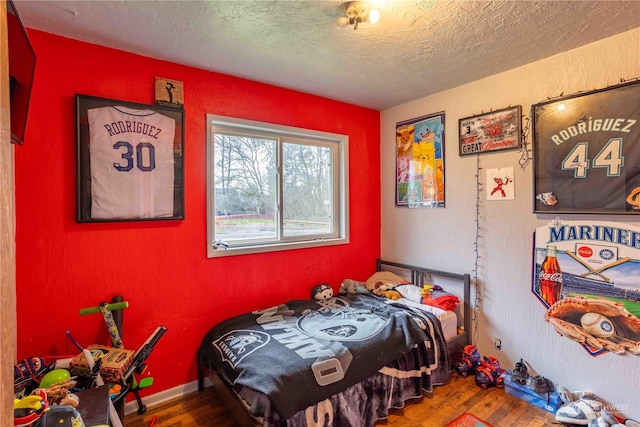 bedroom with a textured ceiling and hardwood / wood-style floors