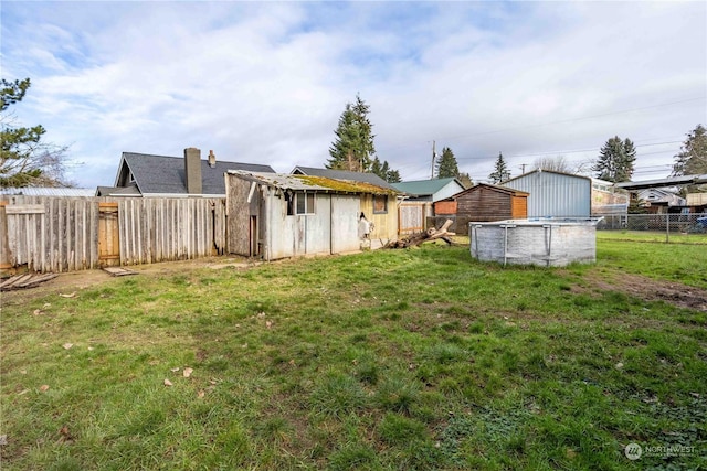 view of yard with a fenced in pool and a storage shed