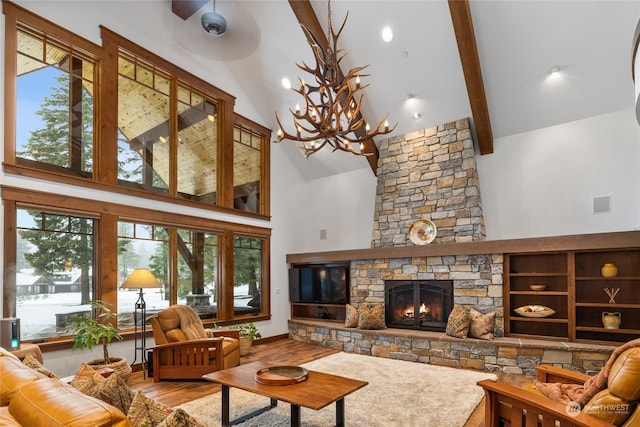 living room featuring beam ceiling, an inviting chandelier, high vaulted ceiling, a fireplace, and hardwood / wood-style flooring