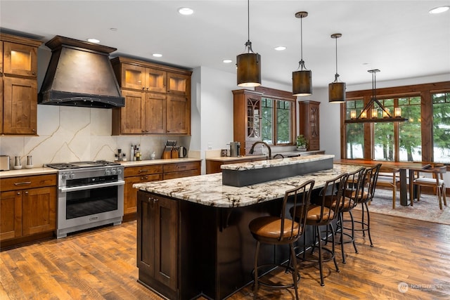 kitchen featuring backsplash, dark hardwood / wood-style flooring, custom range hood, and high end stainless steel range oven