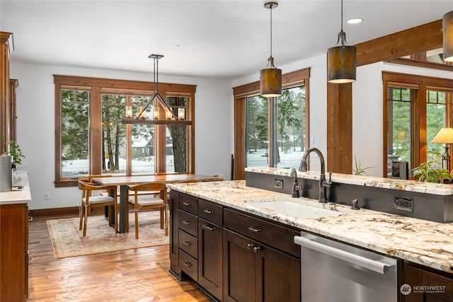 kitchen with dishwasher, light wood-type flooring, hanging light fixtures, and sink