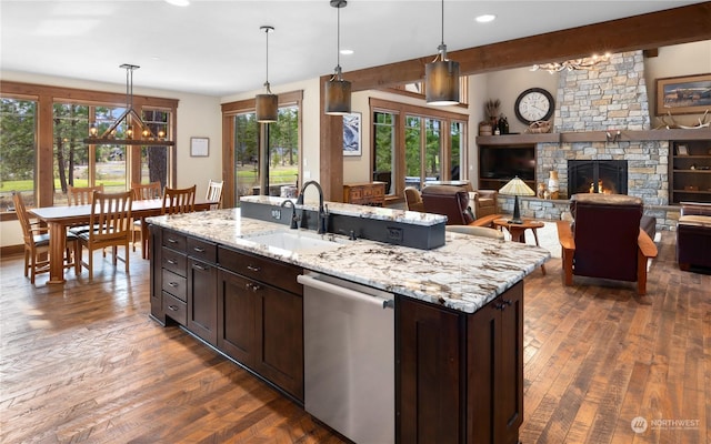 kitchen featuring a fireplace, dishwasher, decorative light fixtures, and sink