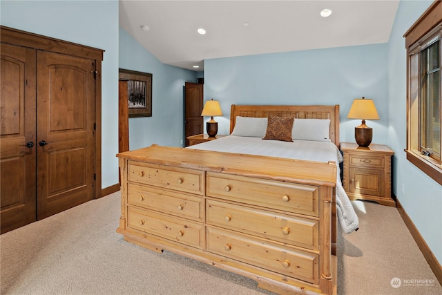 carpeted bedroom featuring a closet and vaulted ceiling