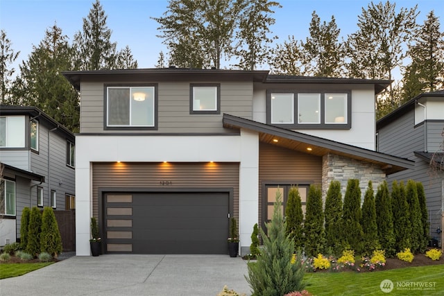 contemporary house featuring a garage, stucco siding, stone siding, and concrete driveway