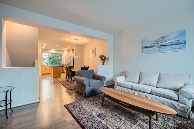 living room with wood-type flooring and a notable chandelier