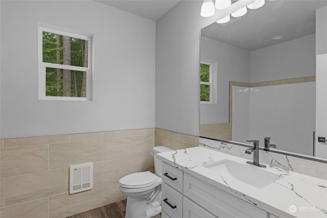 bathroom with walk in shower, toilet, vanity, tile walls, and hardwood / wood-style flooring