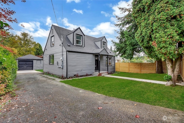 view of front of home featuring a garage, an outbuilding, and a front yard