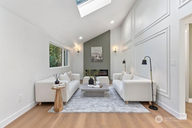 living room with lofted ceiling with skylight and light hardwood / wood-style floors