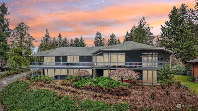 back house at dusk with a wooden deck