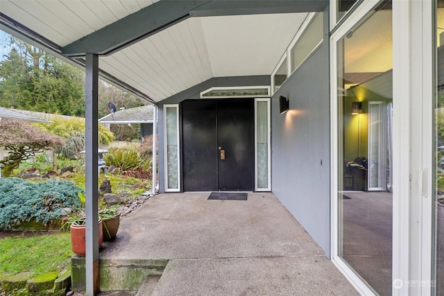 view of exterior entry with a patio area