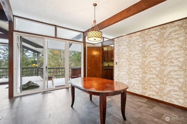 unfurnished dining area with a textured ceiling and beam ceiling