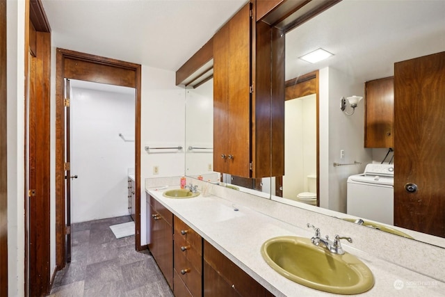 bathroom with toilet, washer / dryer, and vanity