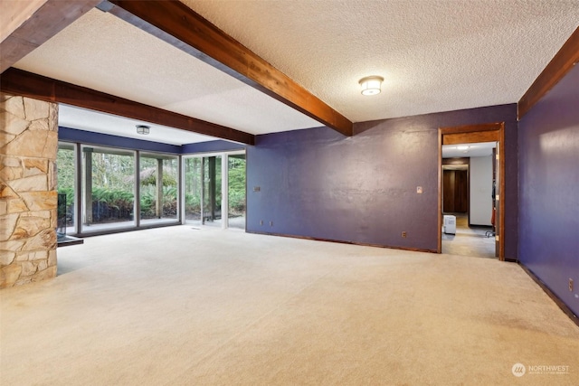 unfurnished living room featuring a textured ceiling, carpet floors, and beamed ceiling