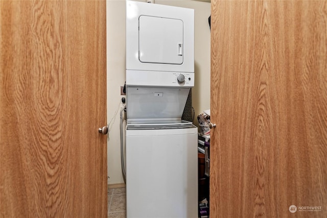 clothes washing area with stacked washer / dryer and light tile patterned flooring