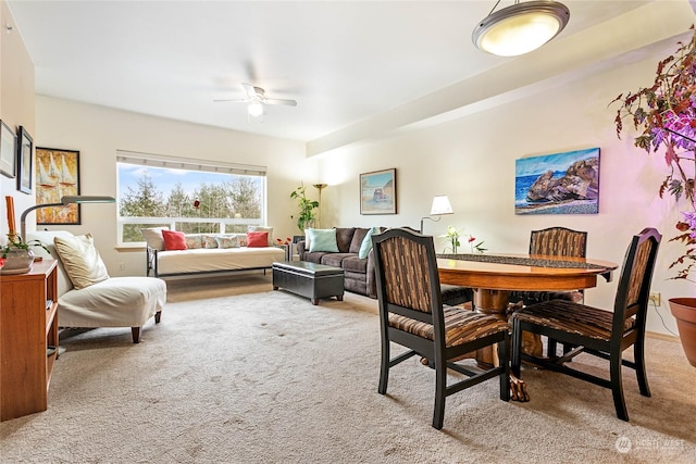 dining space featuring ceiling fan and light carpet